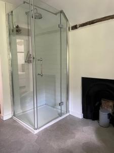 a glass shower in a bathroom with a fireplace at 3 bedroom remote rural idyll on the North Downs in Faversham