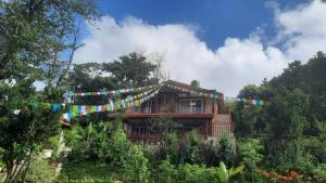 a house with a string of flags in front of it at La Ferme Suntala Bari in Panaoti