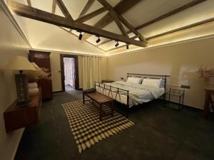 a bedroom with a bed and a bench in a room at La Ferme Suntala Bari in Panaoti