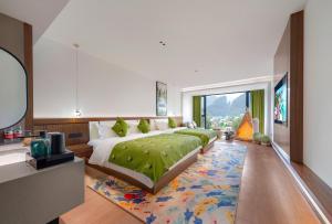 a bedroom with a large bed and a large window at Zhangjiajie National Park East Gate Happy Hotel-River View&City Center&Book Tickets&English Speaking&Free Laundry in Hanqiyu