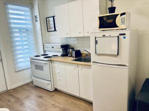 a kitchen with white appliances and a microwave at The Skyline Luxury Unit in Bélanger +10 photos