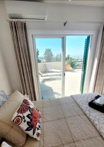 a bedroom with a bed and a large sliding glass door at PJ's Apartment, Paphos, Cyprus in Khlorakas +25 photos