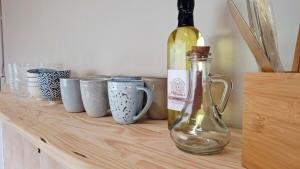 a bottle of wine and cups on a wooden table at Stille Uitsig Hazyview in Hazyview