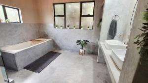 a bathroom with a bath tub and two sinks at Stille Uitsig Hazyview in Hazyview +40 photos