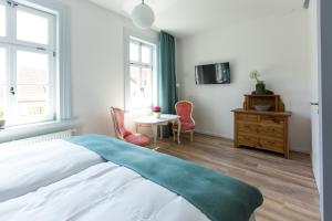 Schlafzimmer mit einem Bett, einem Tisch und Stühlen in der Unterkunft Artem Orbis in Jena