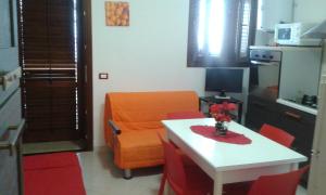 a kitchen with an orange chair and a white table at Casa San Liberale in Trapani