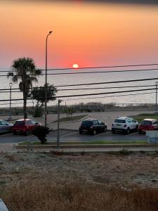 a group of cars parked in a parking lot with the sunset at חוויה בכיכר גולד in Netanya