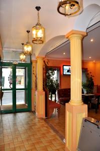 vestíbulo con 2 columnas y sofá en Hotel du Commerce et de Navarre, en Lourdes