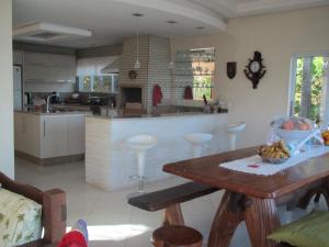 a large kitchen with a table and a counter at Praia Recanto das Pedras in Governador Celso Ramos