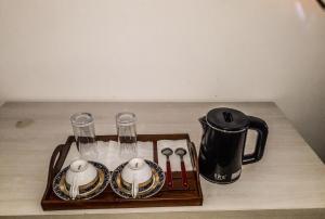 a tray with a tea kettle and glasses on a table at Sasagara Beach Villa in Tangalle