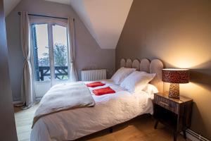 a bedroom with a bed with a lamp and a window at Villa Alexandre III in Dijon