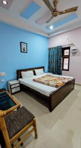 a bedroom with a bed and a blue wall at Hotel Aryaman in Haridwār