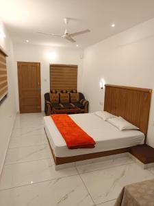 a bedroom with a large bed and a couch at Manjula Homestay in Vagamon