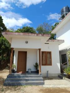 a small white house with stairs in front of it at Manjula Homestay in Vagamon