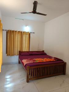a bed in a room with a ceiling at Manjula Homestay in Vagamon +4 photos