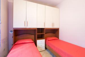 two beds in a room with white cabinets at Annie's Home in La Giustiniana