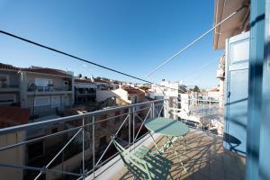 a balcony with a chair and a table at Olive Aura in Mytilene