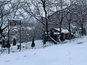 a street sign in the snow in front of a house at Bujtina Shpella e Plakës Çerçan Librazhd in Librazhd