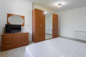 la casa di Anna... في Olgiata: غرفة نوم بسرير وتلفزيون ومرآة