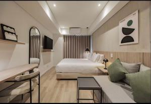 a hotel room with a bed and a couch at Laureles Studios - Tomas in Medellín