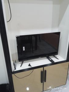 a tv on a shelf in a room at Haven roots in Trivandrum