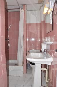 a pink bathroom with a sink and a toilet at Hotel du Commerce et de Navarre in Lourdes +56 photos