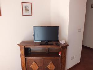 a television sitting on top of a wooden cabinet at Relais C&agrave; Nova Guest House in Bogogno