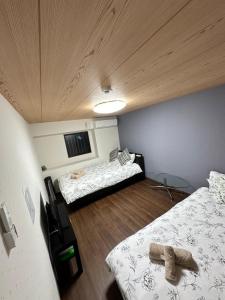 a room with two beds and a ceiling at Small hidden wooden house in Osaka