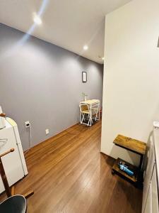 an empty room with a table and a wooden floor at Small hidden wooden house in Osaka