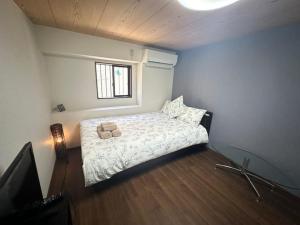a bedroom with a bed with a teddy bear on it at Small hidden wooden house in Osaka +14 photos