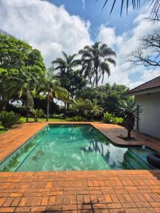 a swimming pool in a yard with palm trees at The Macadamia Nut Farm House in White River