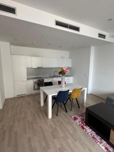 a living room with a table and chairs and a kitchen at Central Walk Apartment in Bratislava +2 photos
