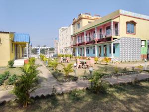 a building with a table and chairs in front of it at Sea Smile Inn in Mandarmoni