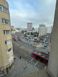 a view of a city street with a red bus at Central Walk Apartment in Bratislava