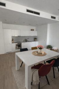 a white kitchen with a white table and chairs at Central Walk Apartment in Bratislava