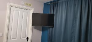 a flat screen tv hanging on a wall next to a door at Morayo in Sandal and Walton