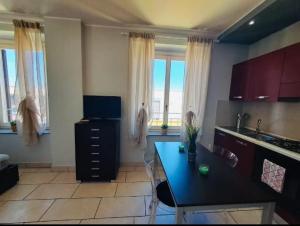 a kitchen with a black counter top and some windows at Appartamento Valentina in Cremona +2 photos