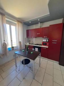 a kitchen with red cabinets and a table in it at Appartamento Valentina in Cremona