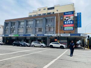 a man standing in the street in front of a building at Bayside Hotel 97 Russell Street in Durban
