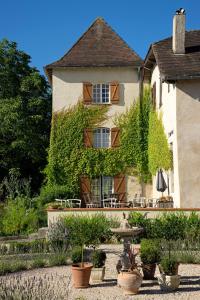 a building with plants and a fountain in front of it at Pure Gardères in Monlezun