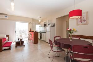 Una cocina y una sala de estar con mesa y sillas. en Apart Hotel Independencia - Luz y Fuerza Patagonia, en Buenos Aires