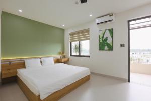 a bedroom with a large white bed and a window at Trà Homestay in Thôn Lại Thê