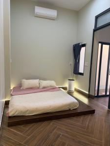 a bedroom with a bed in the middle of a room at Bảo Bối House in Cao Lãnh