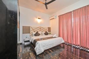 a bedroom with a bed and a red curtain at Puranik sayama in Lonavala