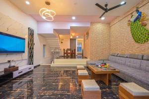 a living room with a couch and a tv at Puranik sayama in Lonavala