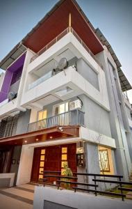 a tall white building with a balcony on it at Puranik sayama in Lonavala