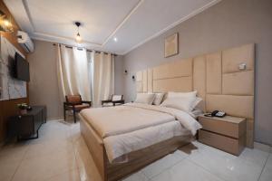 a hotel room with a large bed and a desk at Empire Luxury Hotel in Yaoundé
