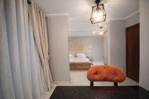 an orange ottoman in a bedroom with a bed at Empire Luxury Hotel in Yaoundé +60 photos