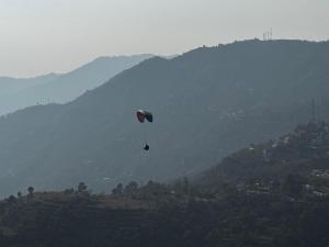 a person flying a kite in the sky over a mountain at Dual Lake in Bhīm Tāl +21 photos