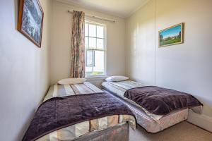 two beds in a room with a window at Ohakune's Yellow Door in Ohakune